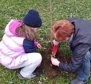 mamma e bambina che piantano un albero